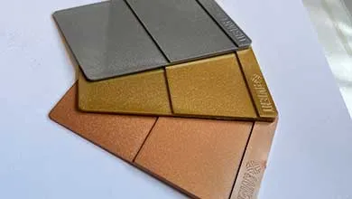 Three metallic, textured swatches: gray, gold, and copper, fanned on white.